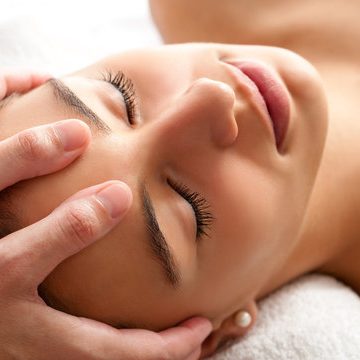 Client receiving a relaxing Indian head massage focusing on the scalp and temples at Divine Lotus in Wolverhampton.