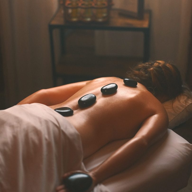 Therapist applying hot stones on a client’s back during a hot stone massage in Wolverhampton